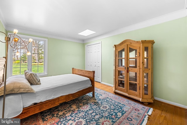 bedroom featuring ornamental molding, baseboards, and hardwood / wood-style flooring