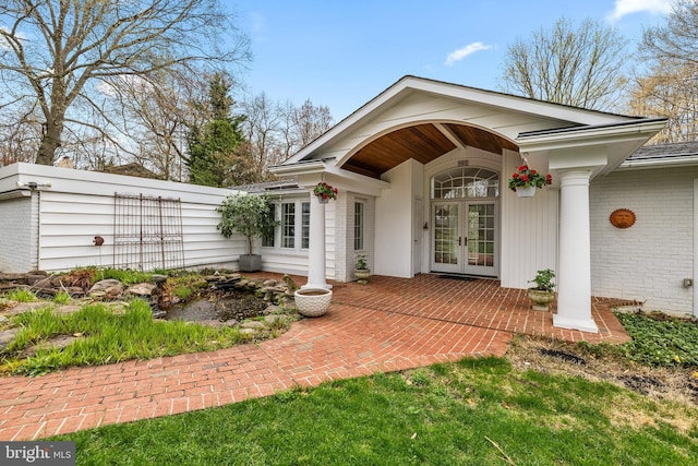 entrance to property with brick siding and french doors