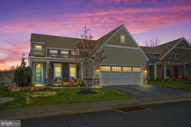 1205 Mosaic Dr, Lebanon, PA 17042 - view of front of home featuring stone siding, an attached garage, aphalt driveway, a lawn, and covered porch