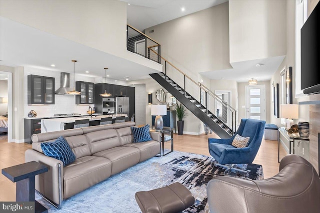 1205 Mosaic Dr, Lebanon, PA 17042 - living room featuring light wood-style flooring, a high ceiling, baseboards, and stairs