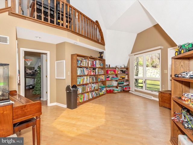 sitting room featuring high vaulted ceiling, baseboards, wood finished floors, and visible vents