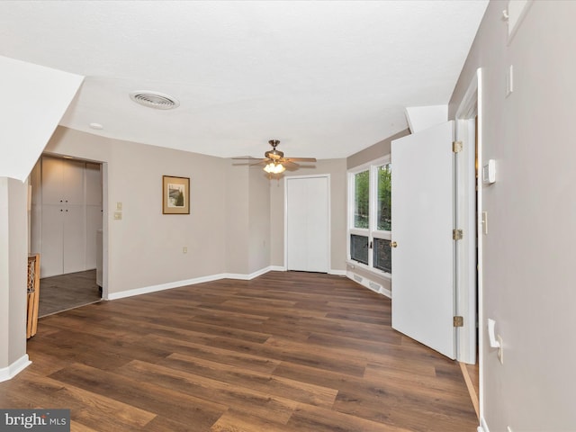 spare room featuring baseboards, a ceiling fan, wood finished floors, and visible vents