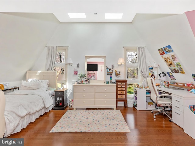 bedroom with a skylight, wood finished floors, high vaulted ceiling, and multiple windows