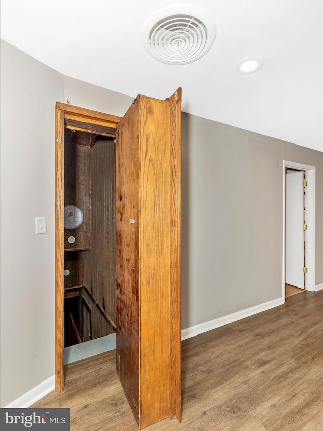 interior space featuring recessed lighting, wood finished floors, visible vents, and baseboards