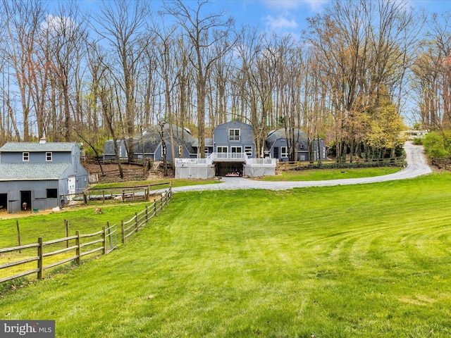 view of yard featuring fence, an outbuilding, and a barn