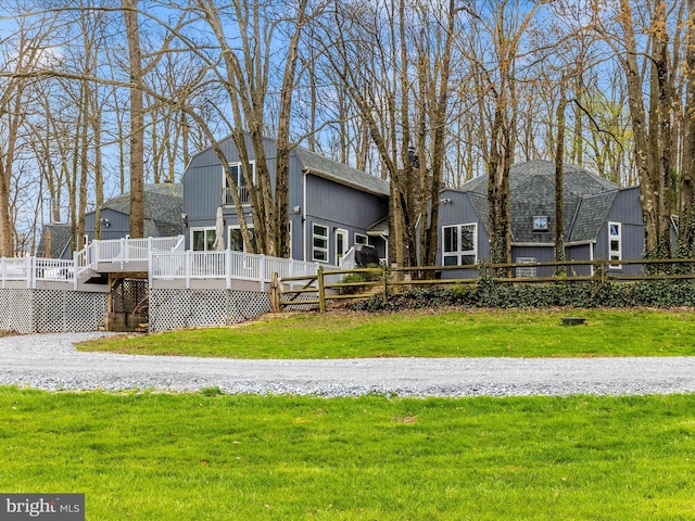 rear view of property with a lawn and a deck