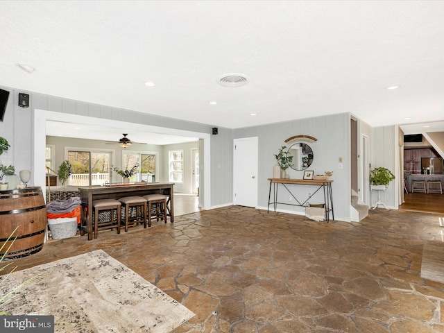living area with recessed lighting, stone flooring, visible vents, and ceiling fan