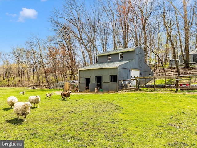 exterior space with a chimney, fence, a shingled roof, an outdoor structure, and a detached garage
