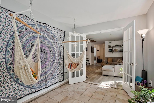 tiled dining room featuring a ceiling fan and french doors
