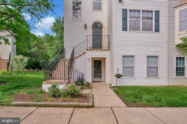 multi unit property with a front lawn and stairway