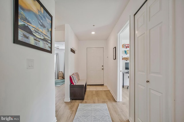 hallway featuring light wood finished floors, recessed lighting, and baseboards