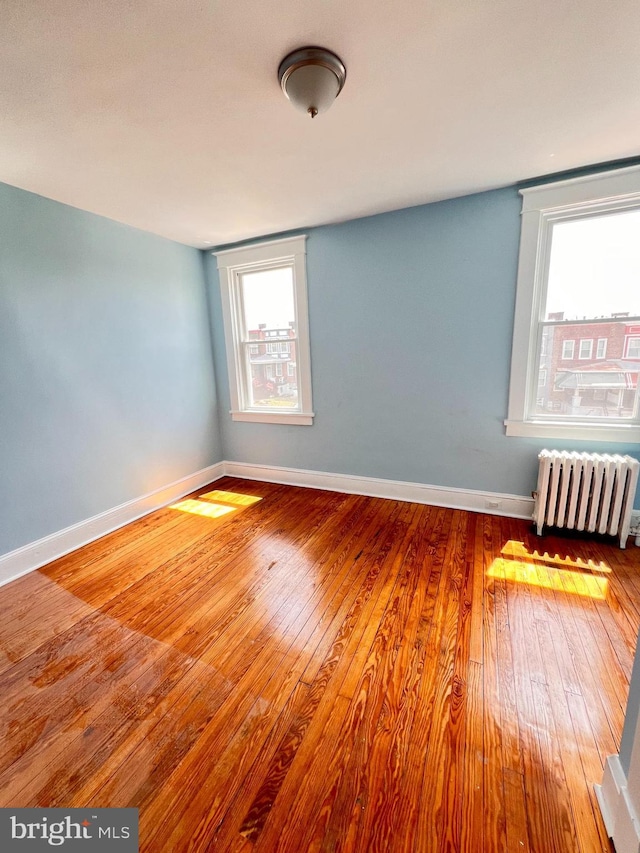 2328 W Lexington St, Baltimore, MD 21223 - spare room with radiator heating unit, baseboards, and wood-type flooring