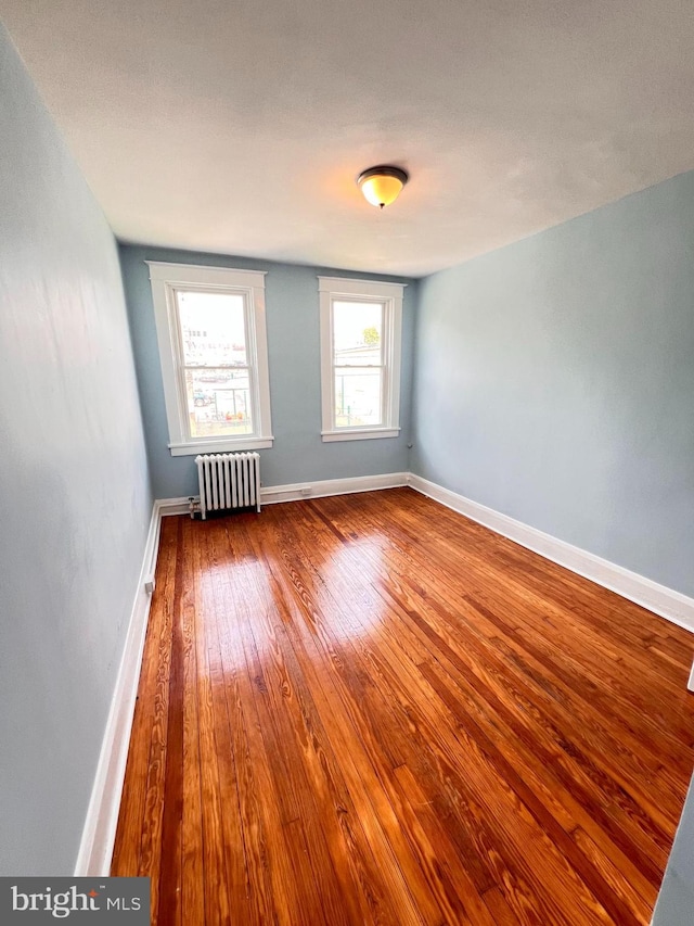 2328 W Lexington St, Baltimore, MD 21223 - unfurnished room with radiator, wood finished floors, and baseboards