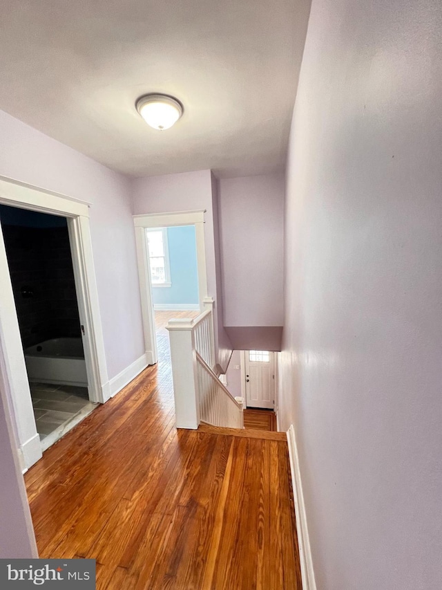 2328 W Lexington St, Baltimore, MD 21223 - corridor featuring baseboards, wood finished floors, and an upstairs landing