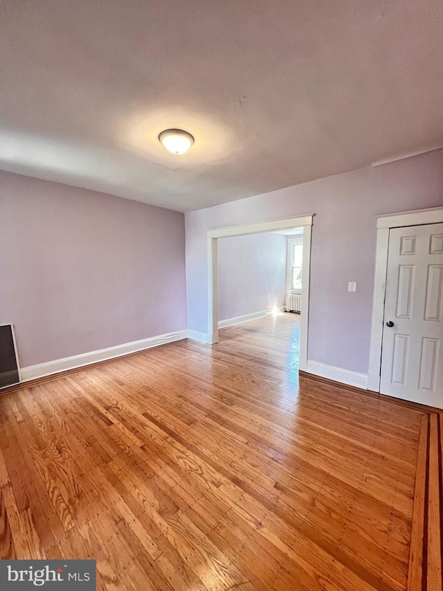 2328 W Lexington St, Baltimore, MD 21223 - empty room with baseboards, radiator heating unit, and light wood finished floors