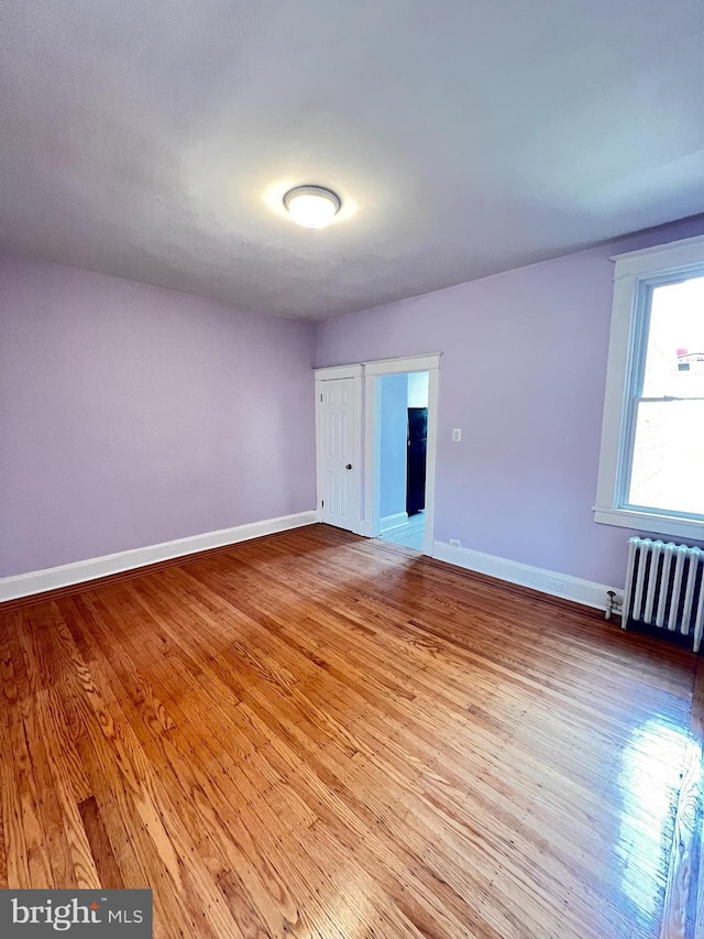 2328 W Lexington St, Baltimore, MD 21223 - unfurnished room with wood-type flooring, baseboards, and radiator heating unit
