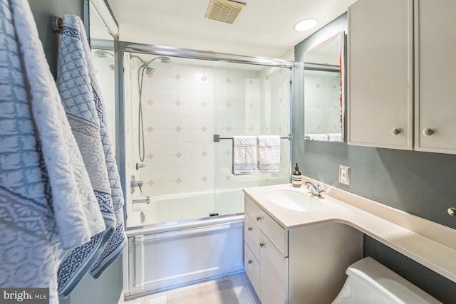 bathroom featuring shower / bath combination with glass door, tile patterned floors, visible vents, toilet, and vanity