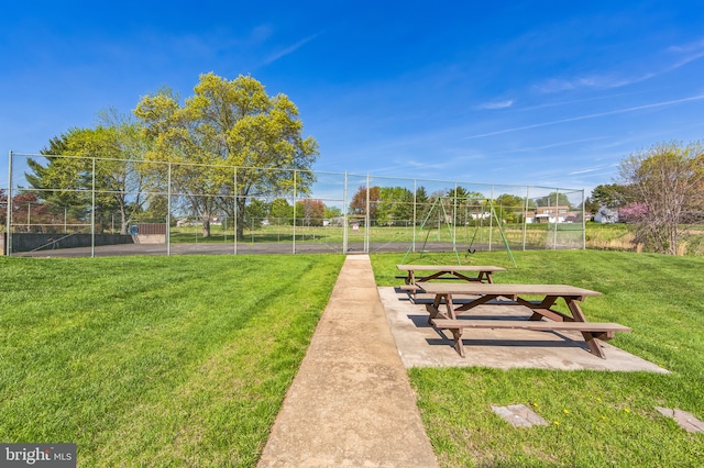 view of property's community with a lawn and fence