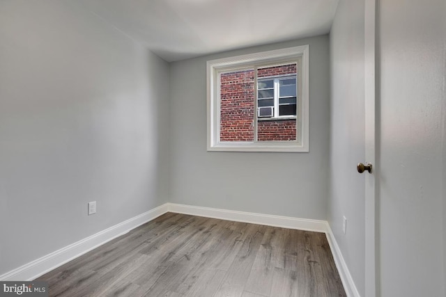 empty room with baseboards and wood finished floors