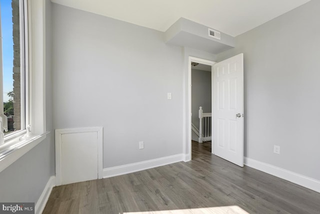 unfurnished bedroom featuring visible vents, baseboards, and wood finished floors