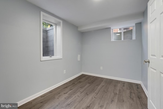 below grade area with baseboards and wood finished floors