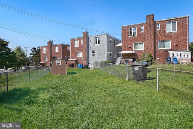 view of yard featuring a shed, a fenced backyard, and an outdoor structure