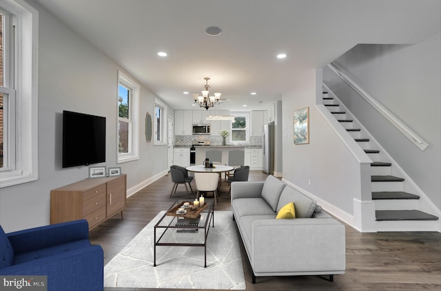 living area featuring baseboards, an inviting chandelier, recessed lighting, stairway, and dark wood-style floors