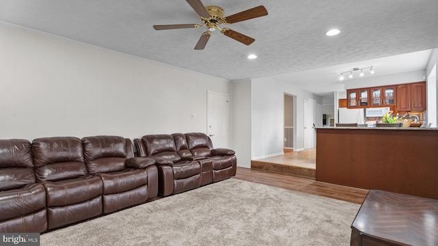 living area featuring wood finished floors, baseboards, a ceiling fan, and recessed lighting