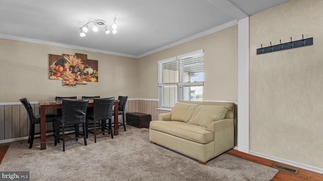 dining room with crown molding, wood finished floors, baseboards, and visible vents