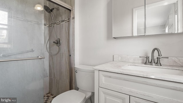 full bath featuring a shower stall, vanity, and toilet