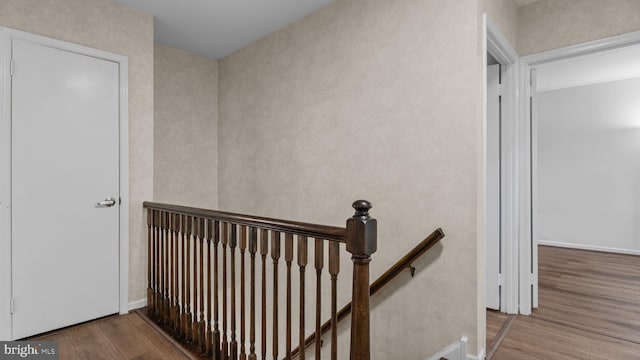 staircase featuring baseboards and wood finished floors