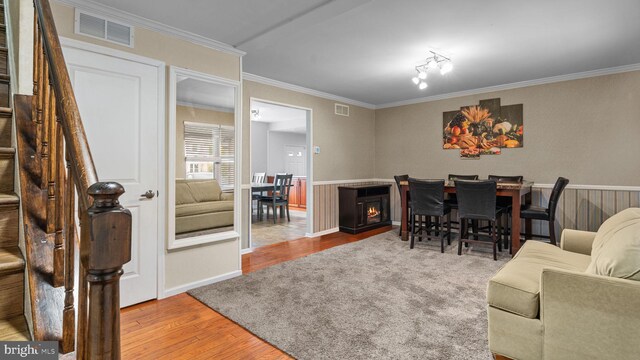 interior space with stairway, visible vents, crown molding, and wood finished floors