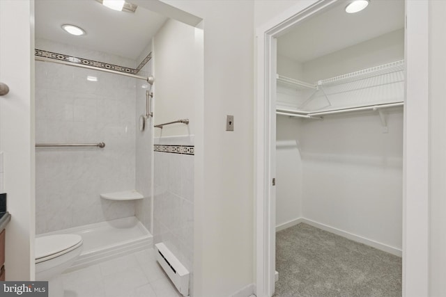 bathroom featuring a baseboard radiator, a tile shower, toilet, and vanity