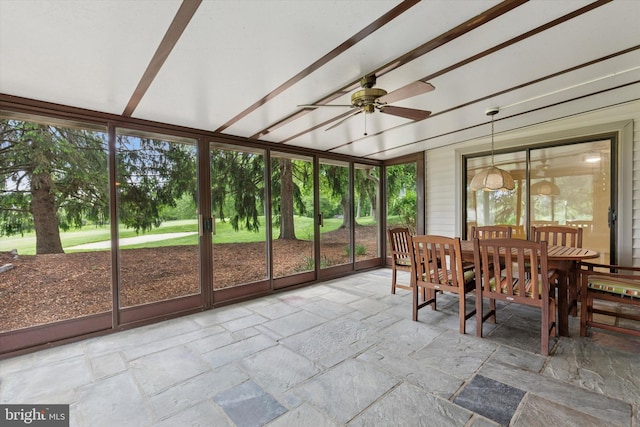 sunroom / solarium featuring a ceiling fan, outdoor dining space, and plenty of natural light