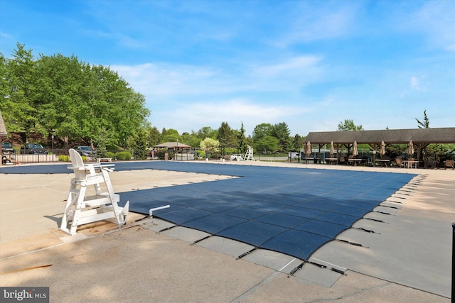 community pool featuring a gazebo, fence, and a patio area