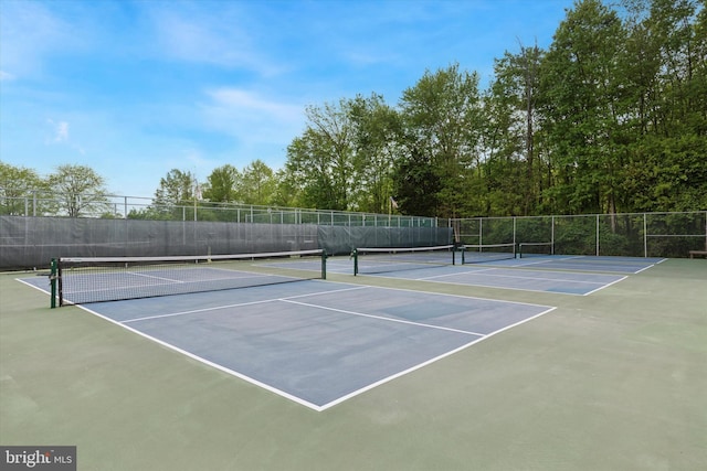view of tennis court featuring community basketball court and fence