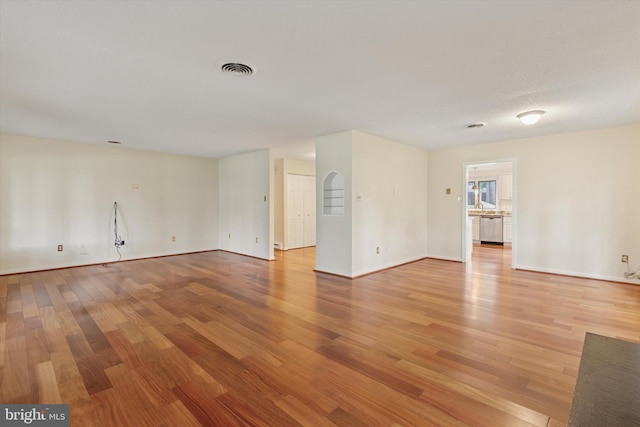empty room featuring light wood-type flooring and baseboards