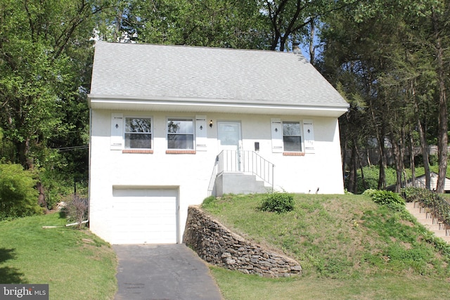 view of front of house featuring roof with shingles, asphalt driveway, stucco siding, and an attached garage