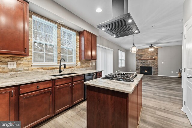 6319 Seton Ridge Dr, Baltimore, MD 21207 - kitchen featuring a stone fireplace, wall chimney range hood, gas stovetop, ceiling fan, and a sink