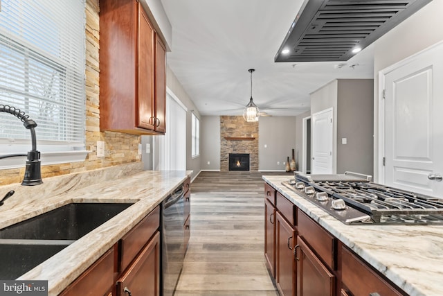 6319 Seton Ridge Dr, Baltimore, MD 21207 - kitchen with light stone counters, light wood-style floors, gas stovetop, stainless steel dishwasher, and a sink