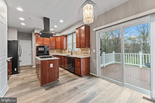 6319 Seton Ridge Dr, Baltimore, MD 21207 - kitchen with island range hood, light wood-style floors, visible vents, and black appliances