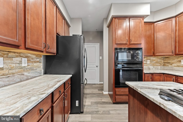 6319 Seton Ridge Dr, Baltimore, MD 21207 - kitchen with light wood-style floors, black appliances, light stone counters, and decorative backsplash