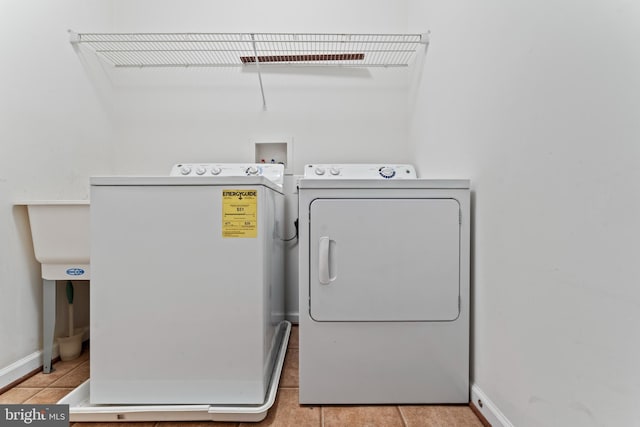 6319 Seton Ridge Dr, Baltimore, MD 21207 - laundry room with laundry area, light tile patterned floors, baseboards, and washer and clothes dryer