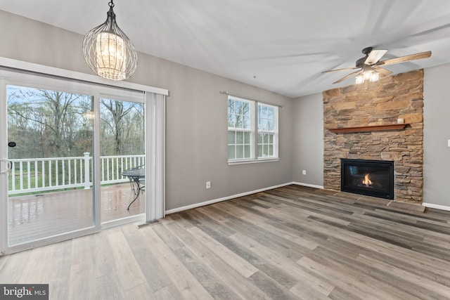 6319 Seton Ridge Dr, Baltimore, MD 21207 - unfurnished living room featuring visible vents, baseboards, a fireplace, wood finished floors, and ceiling fan with notable chandelier