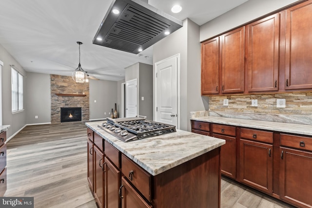 6319 Seton Ridge Dr, Baltimore, MD 21207 - kitchen with light wood-style flooring, tasteful backsplash, stainless steel gas cooktop, open floor plan, and extractor fan