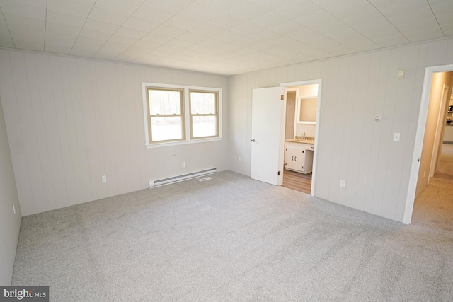 unfurnished bedroom featuring carpet, ensuite bath, a baseboard radiator, and a sink