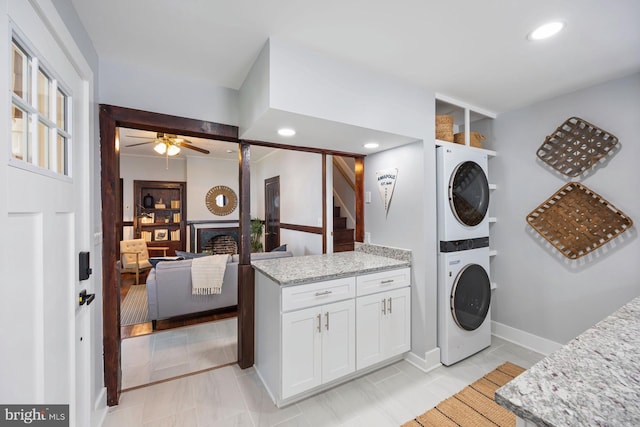 179 Green St, Annapolis, MD 21401 - washroom featuring stacked washing machine and dryer, a ceiling fan, a fireplace, recessed lighting, and baseboards