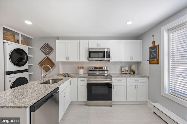 179 Green St, Annapolis, MD 21401 - kitchen featuring stainless steel appliances, a sink, estacked washer and dryer, a baseboard radiator, and healthy amount of natural light