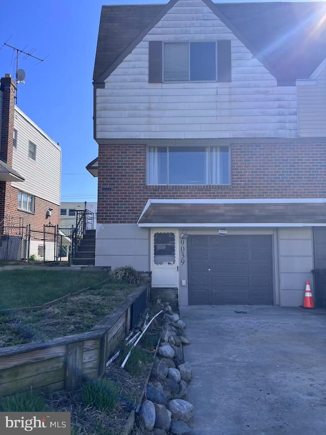 view of front of house with a garage, fence, concrete driveway, and a front lawn