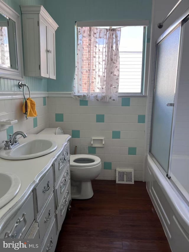 bathroom with toilet, wainscoting, visible vents, a sink, and wood finished floors